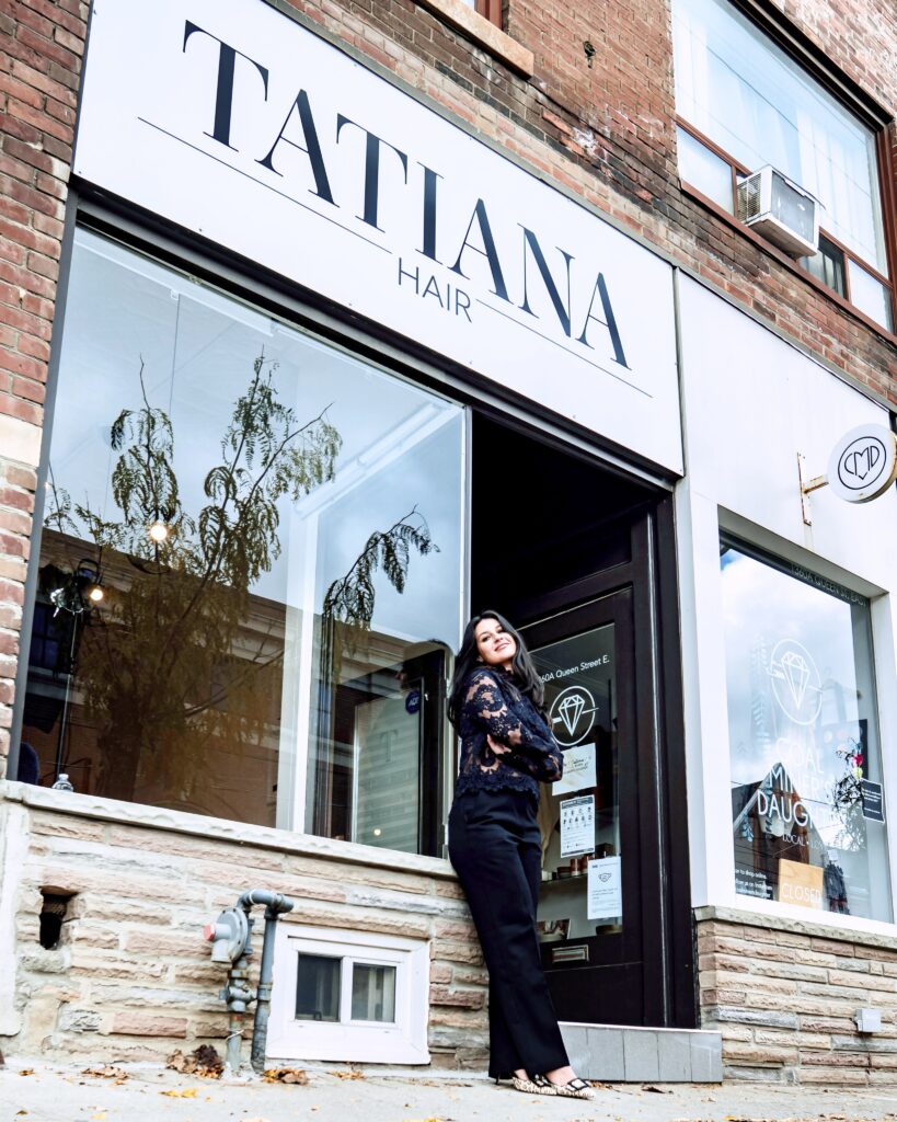 Tatiana standing in front of Tatiana Hair salon in Toronto, showcasing her expertise as Toronto’s best hair colourist, balayage, and blonde specialist