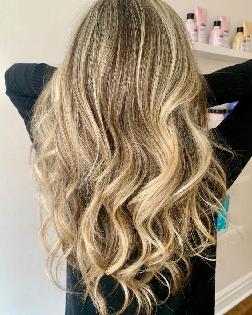 Image of a stunning blonde balayage in Toronto featuring soft, hand-painted highlights seamlessly blended for a sun-kissed, natural-looking glow